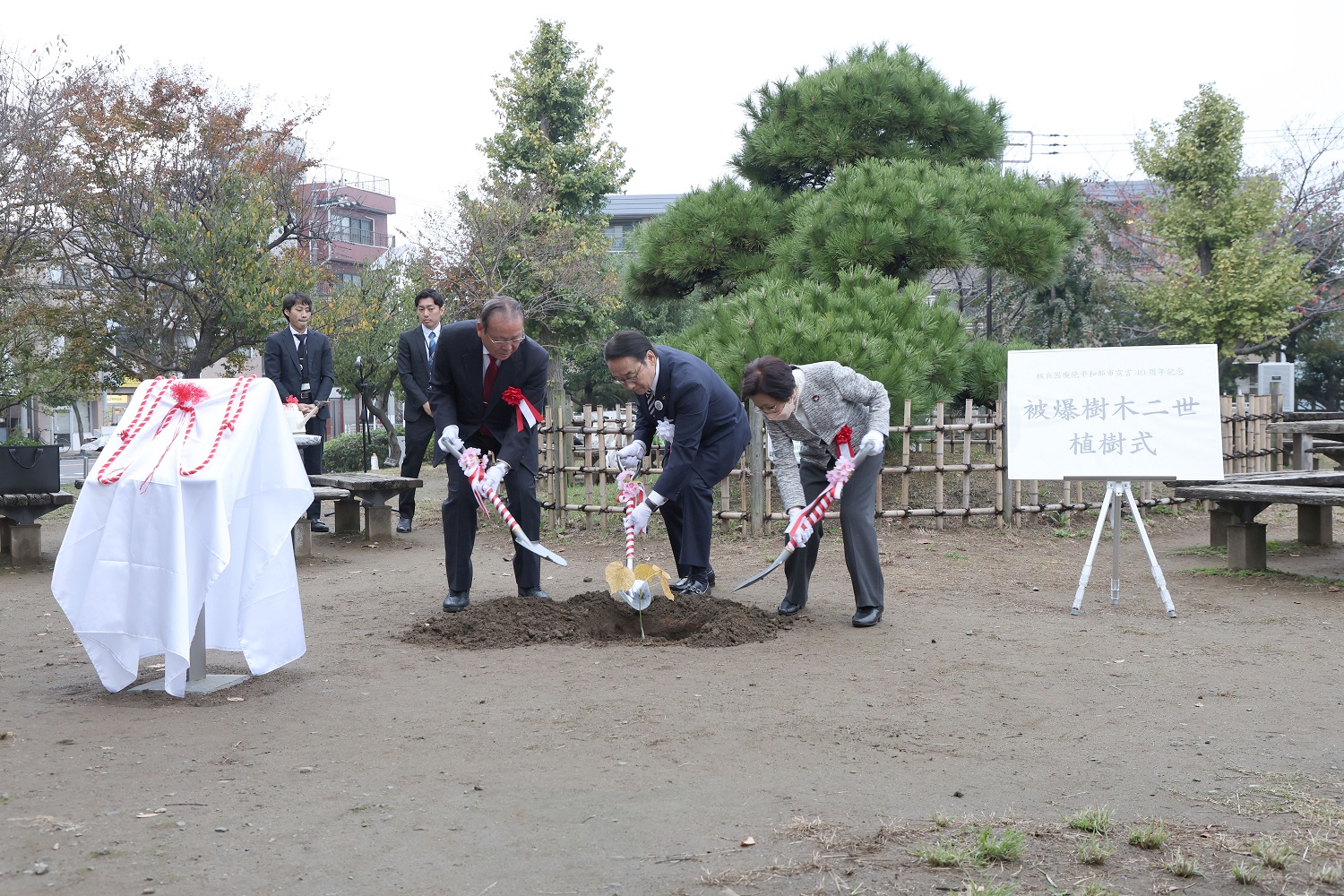 市長と来賓が土をかけている様子