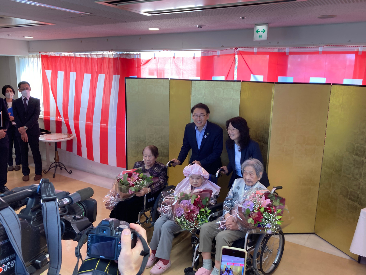 写真：高齢者に花を贈呈し一緒に記念写真を撮る市川市長
