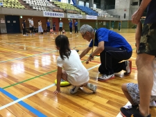 写真：子どもにカローリングを教えるスポーツ推進委員