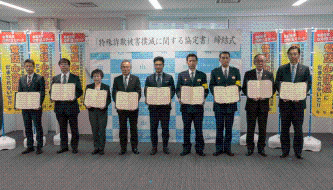 写真:9者がそれぞれ協定書をもって並んでいる
