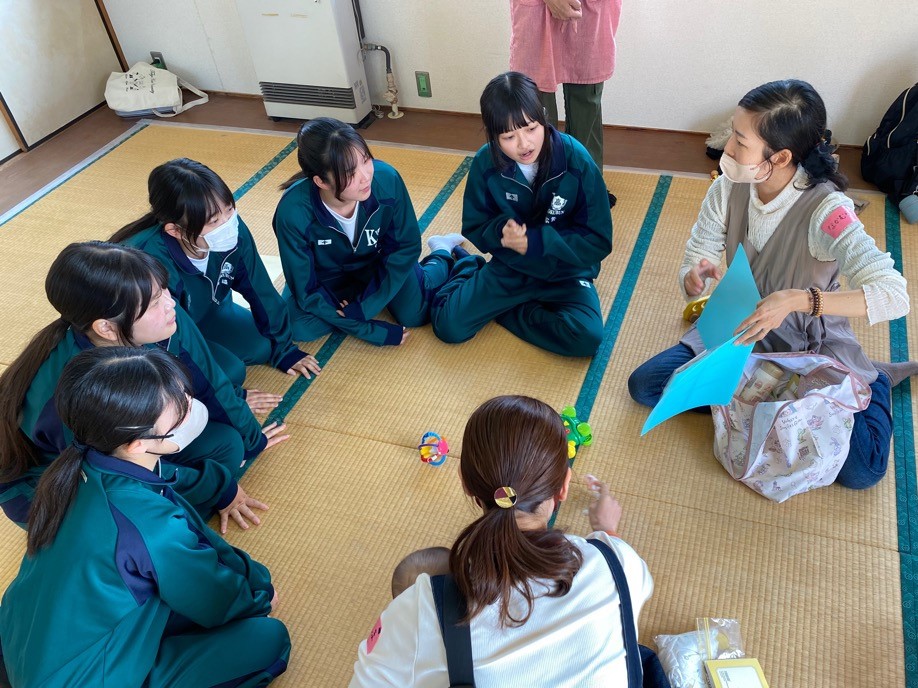 写真:国分高校の生徒が円形に座って保護者の説明を聞いている様子