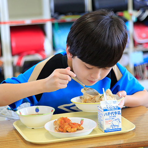 写真：学校の給食を食べる男の子