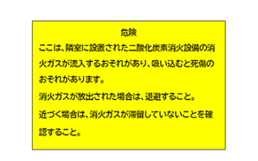 注意銘板：危険　ここは、隣室に設置された二酸化炭素消火設備の消火ガスが流入するおそれがあり、吸い込むと死傷のおそれがあります。消火ガスが放出された場合は、退避すること。近づく場合は、消火ガスが滞留していないことを確認すること。