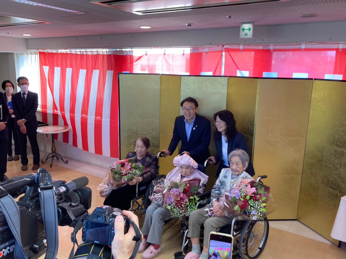 写真:高齢者に花を贈呈し一緒に記念写真を撮る市川市長