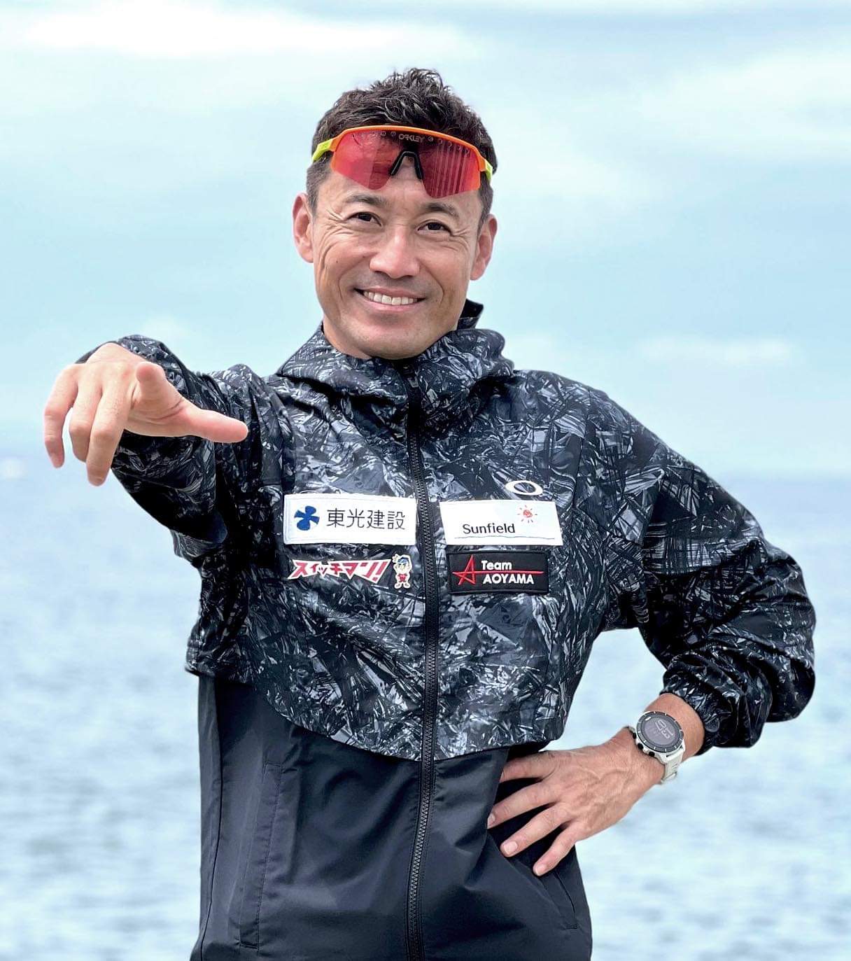 写真:青山氏が笑顔で撮影者側を指さしている
