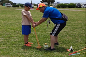 写真:子どもにグラウンドゴルフの打ち方を教えるスポーツ推進委員