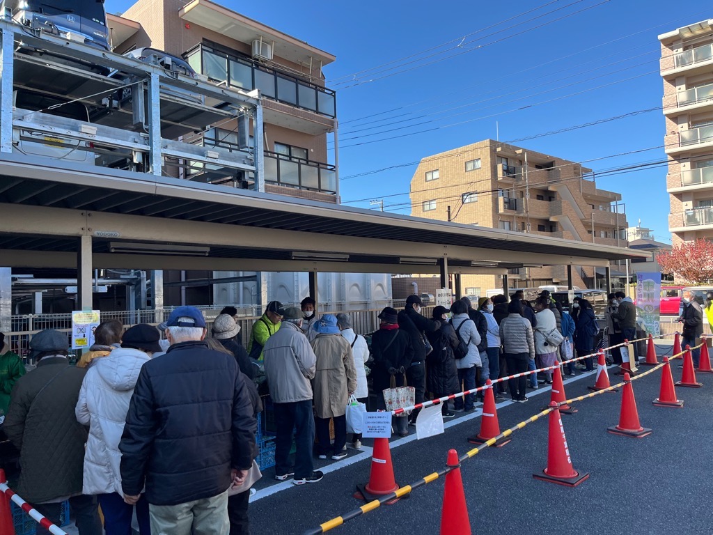 直売組合の野菜列に並ぶ人