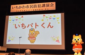 写真:いちパトくんの着ぐるみが登場し、決定した愛称をプロジェクターで発表している。