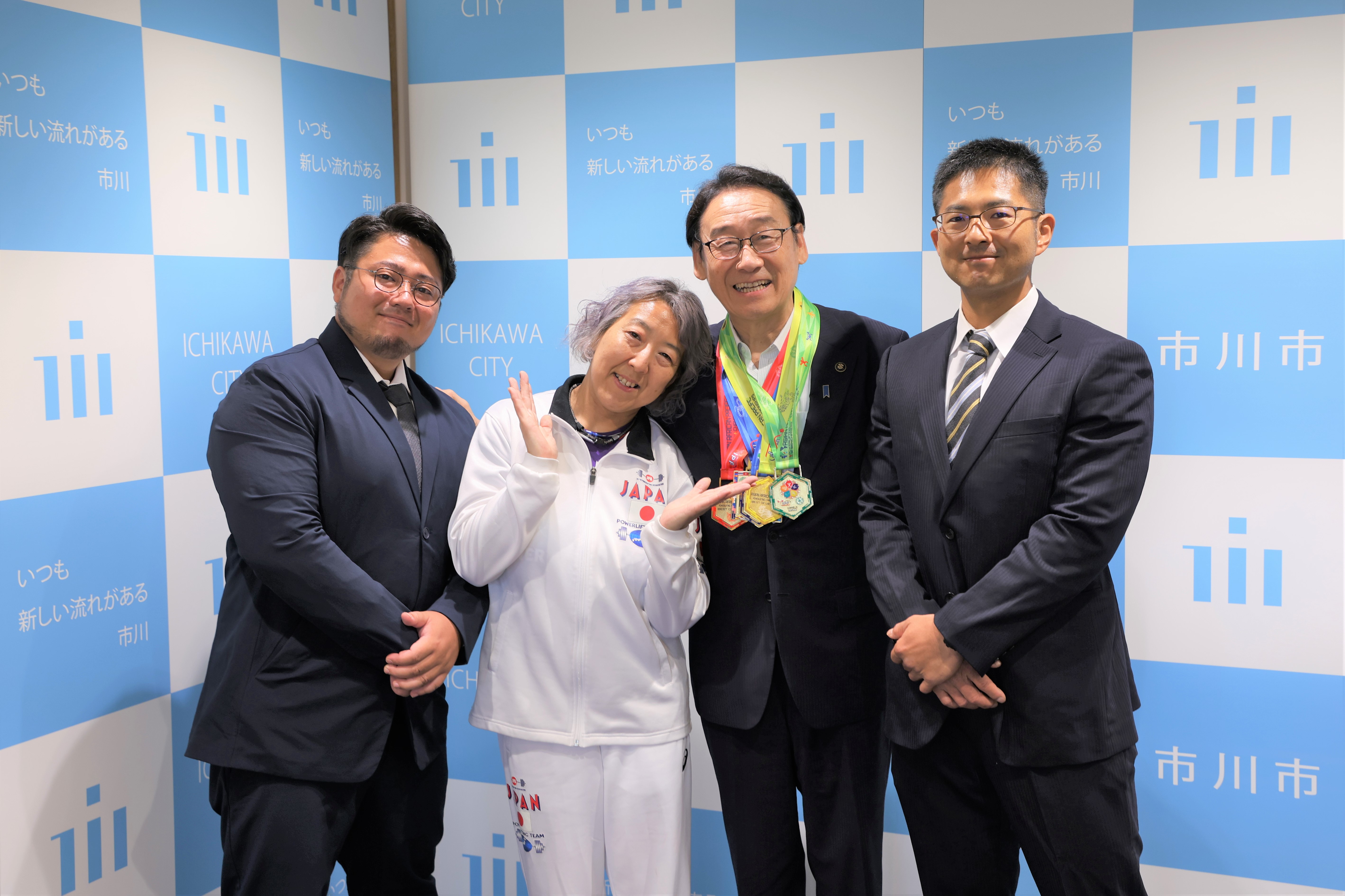 写真：田中市長、伊藤治美選手、小林弘典トレーナー、中澤悠人コーチの集合写真
