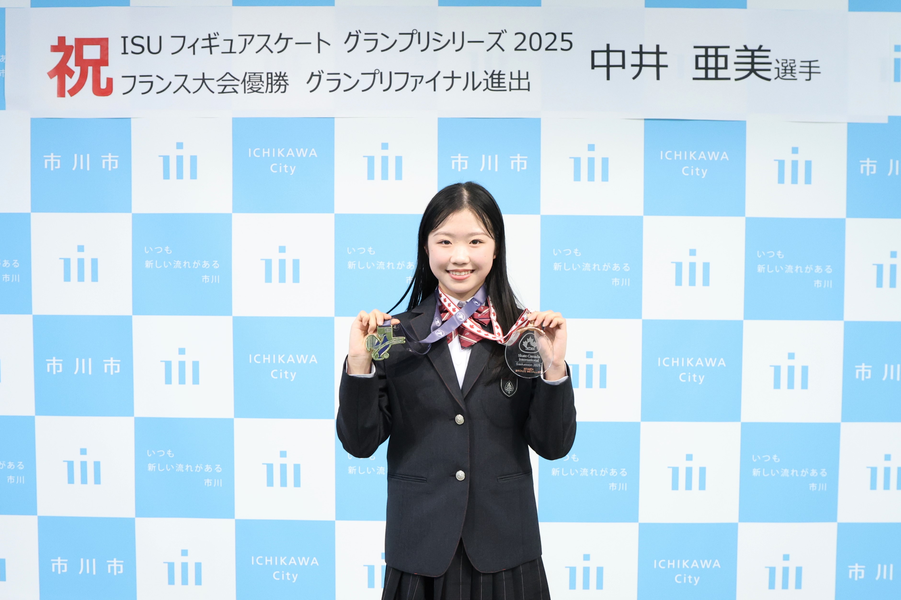 写真:2つのメダルをカメラに向け、笑顔の中井亜美選手