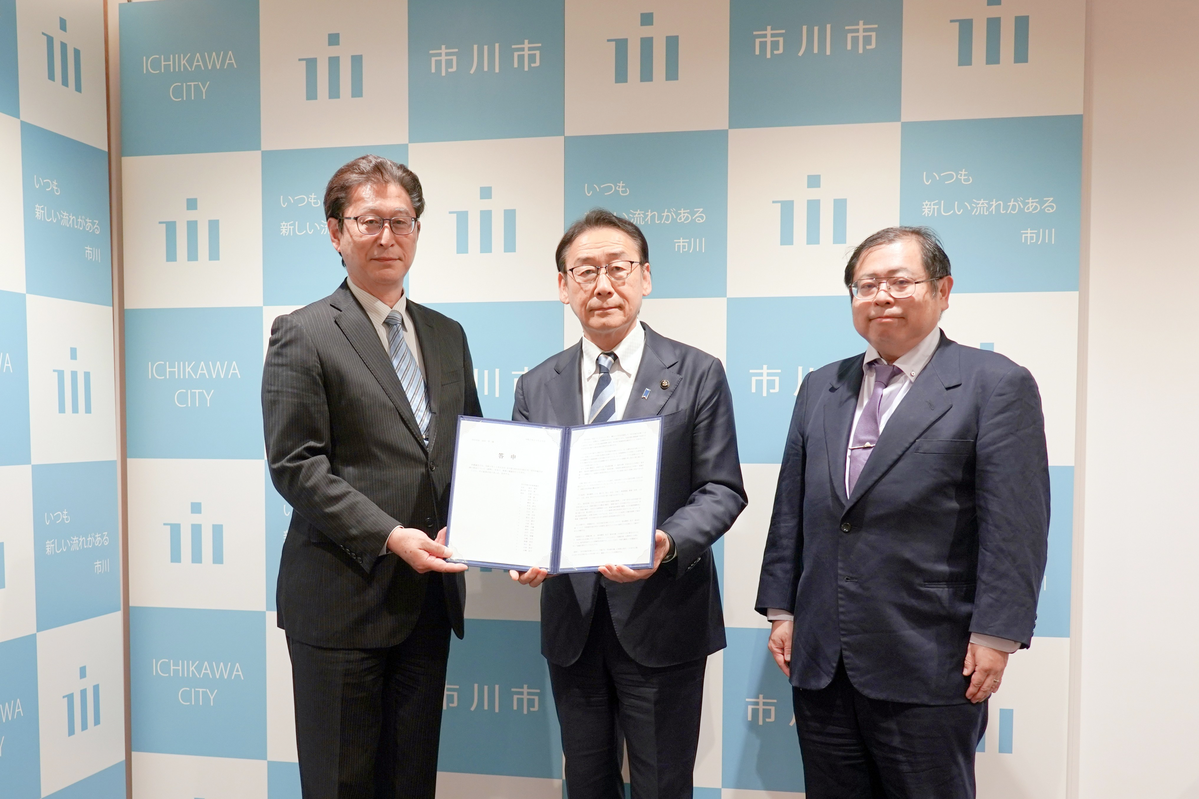 市川市総合計画審議会会長・副会長と市川市長が答申を開いて並んでいる写真