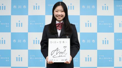 写真：「市川市の皆様へ」と書かれたサイン色紙を持っている中井亜美選手