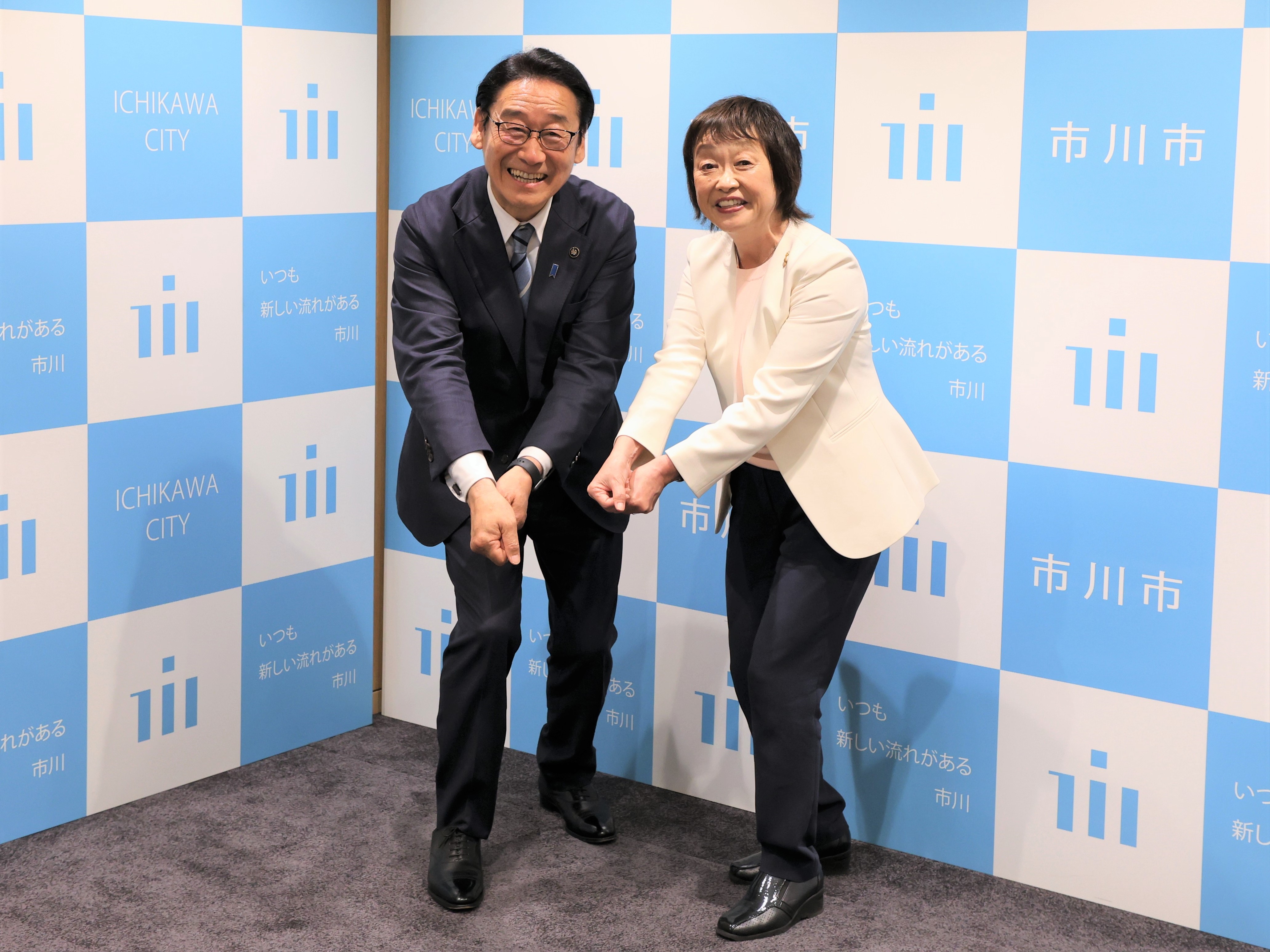 写真：フロアホッケーの構えでポーズをとる田中市長と増田明美会長