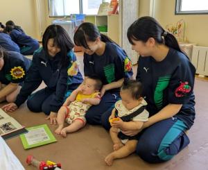 高校生とお膝の上にすわる赤ちゃんの写真
