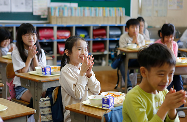 写真:学校で給食を食べる前に「いただきます」をする様子