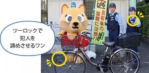 ツーロックした自転車の後ろに立ついちパトくんと警察官の写真