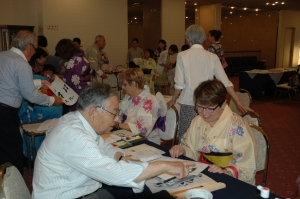 浴衣を着て書道に挑戦するイッシー・レ・ムリノー市民の画像