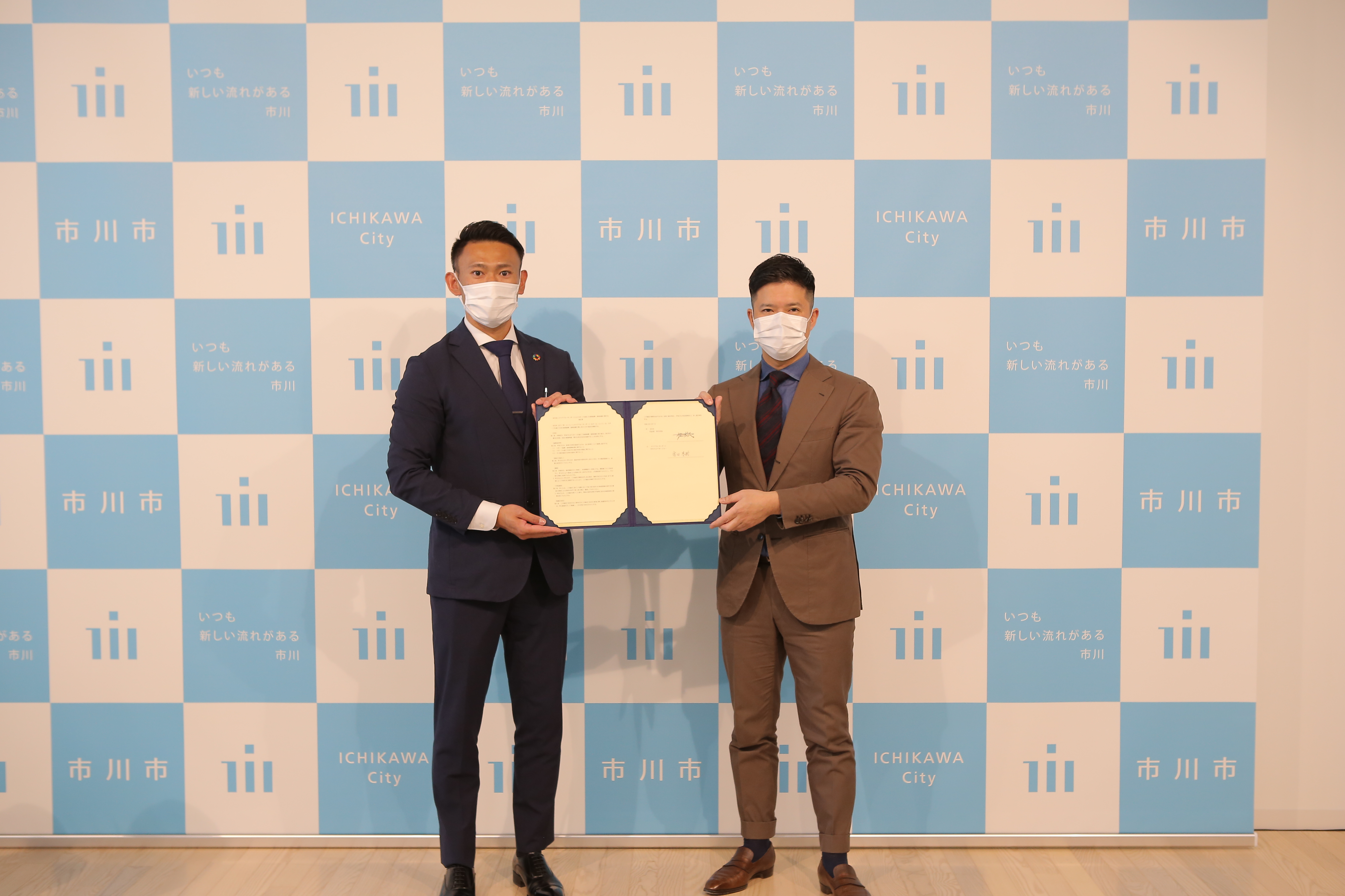 写真：クラブブルーサンダースゼネラルマネージャーと市川市長が協定書を持っている様子