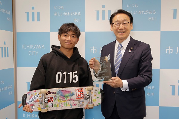 写真：スケートボードを持って並ぶ長尾選手と田中市長