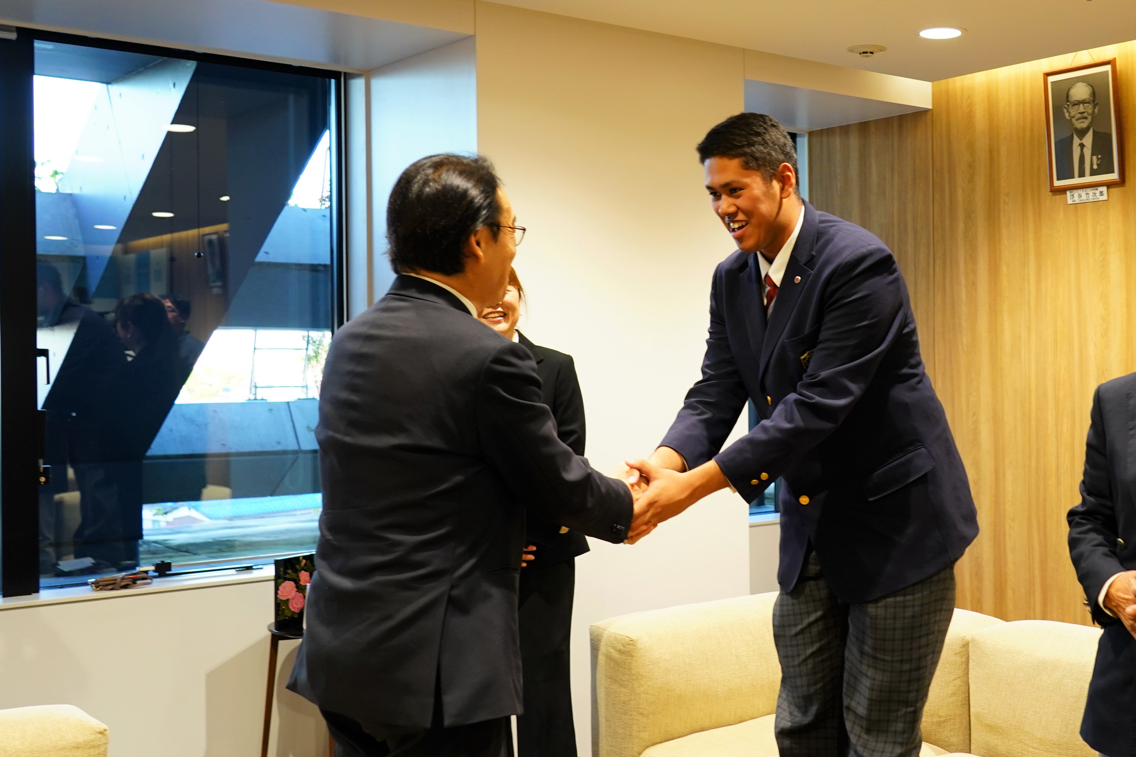 写真：握手する田中市長と菊地ハルン選手