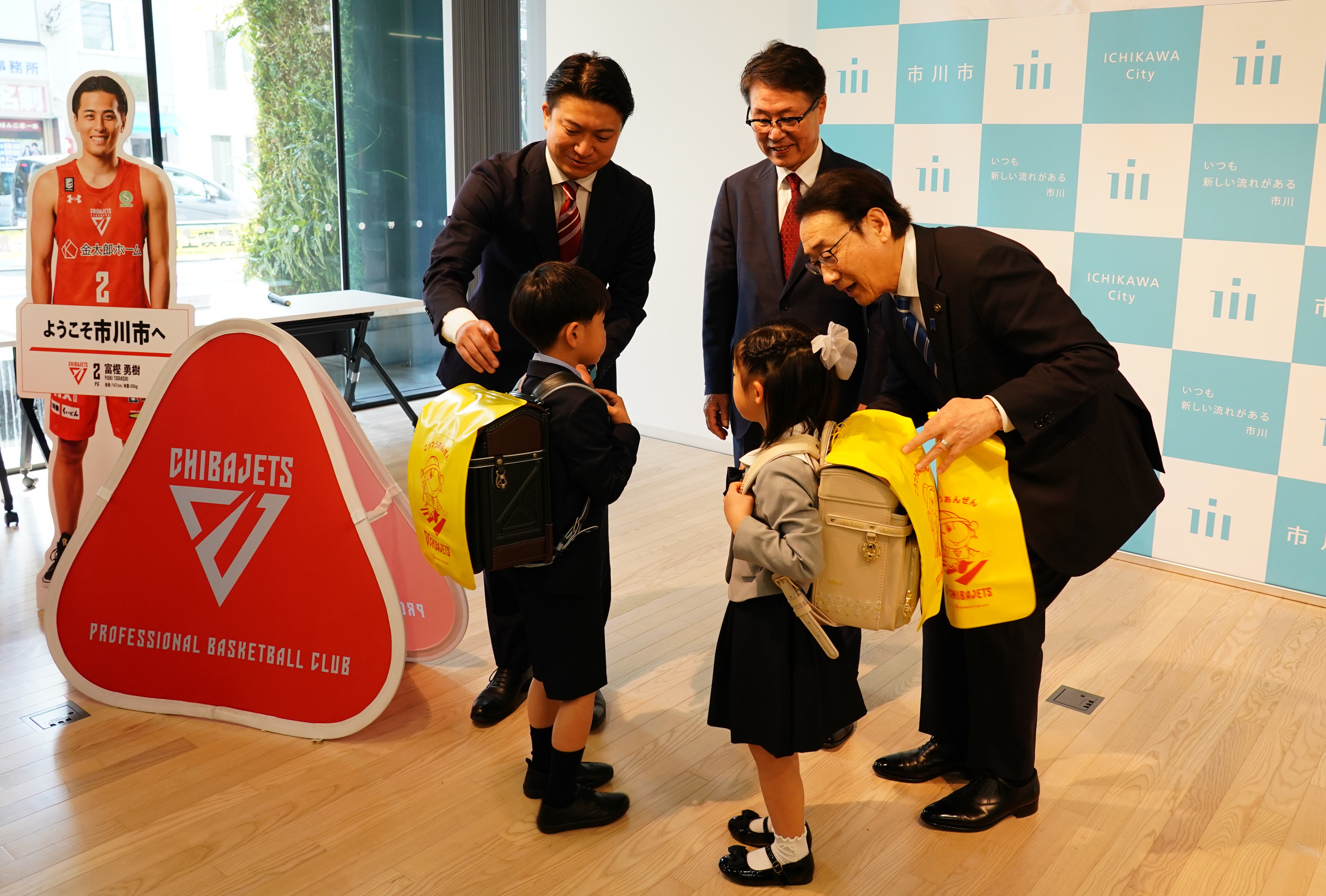 写真：ランドセルカバーを新入生代表児童へ寄贈する様子