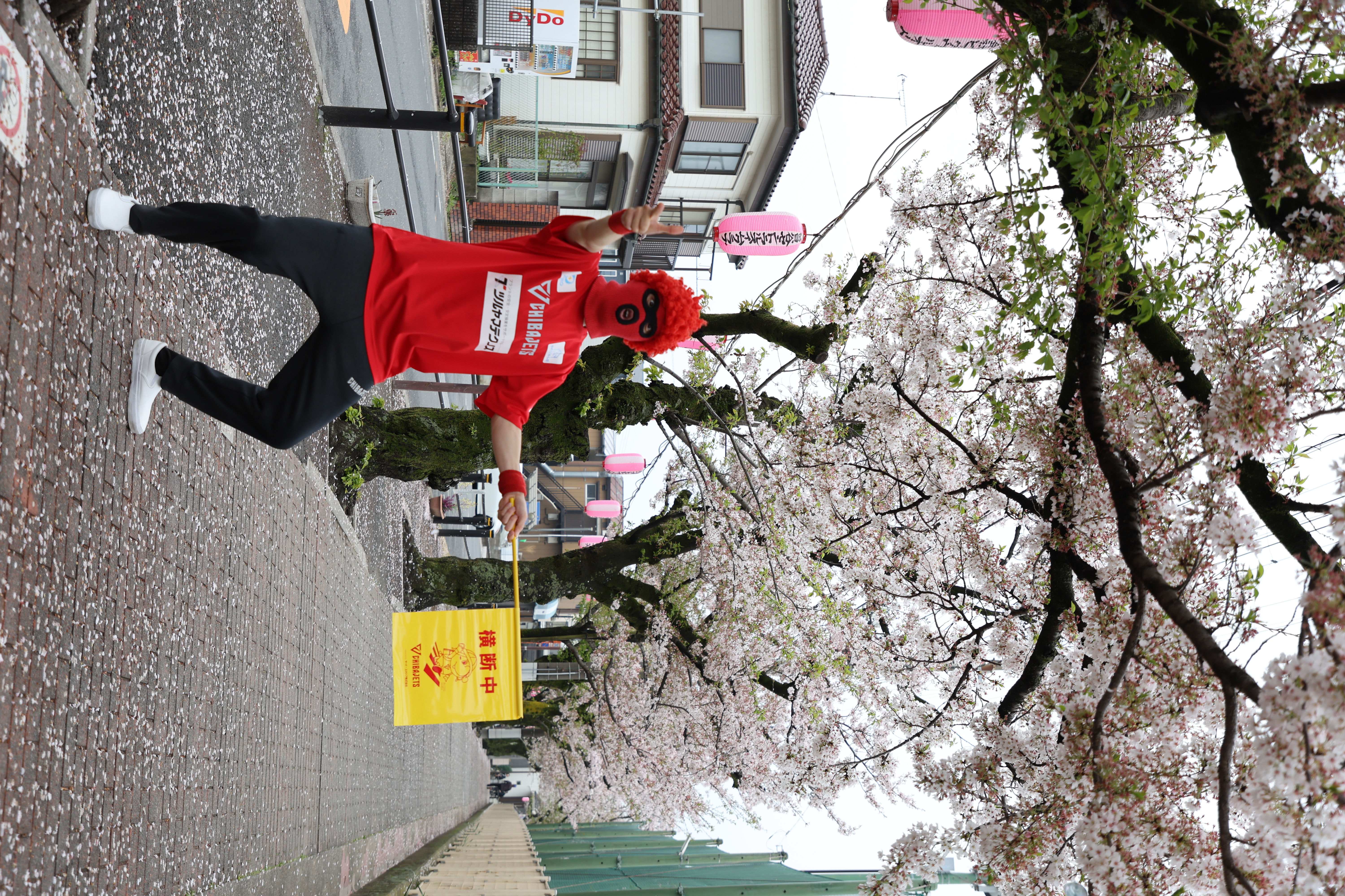 写真：交通安全旗を持っているマスク・ド・オッチー