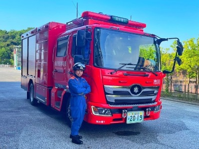 消防車の横に立つ碓井消防士の写真