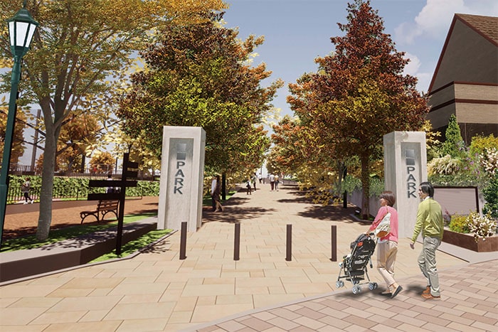 写真:子どもを乗せたベビーカーを押して公園の入口を入っていく夫婦