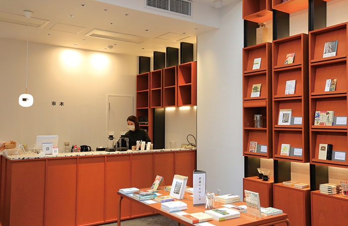 写真:壁一面には本棚があり、テーブルにも本が並んでいる「市本」のスペース