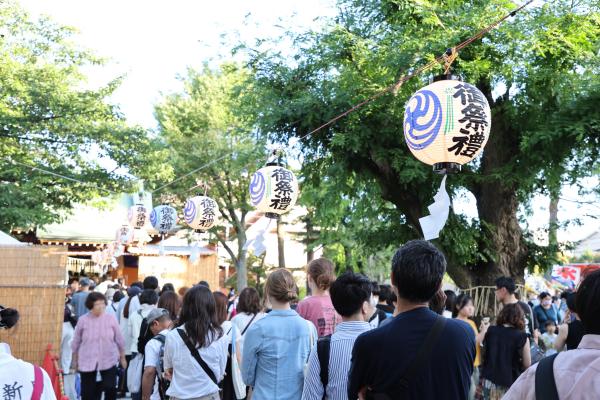 写真：お祭りの提灯の下で並ぶ人たち